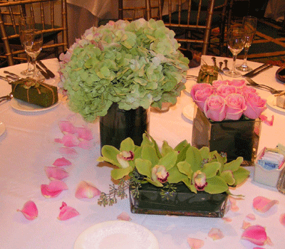 Wedding vases arrangements featuring a mass of compact Hydrangeas,cymbidium orchids and roses by Joys Florist